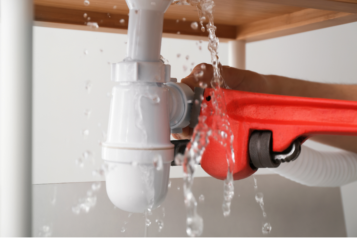 Handwerker reinigt einen Siphon