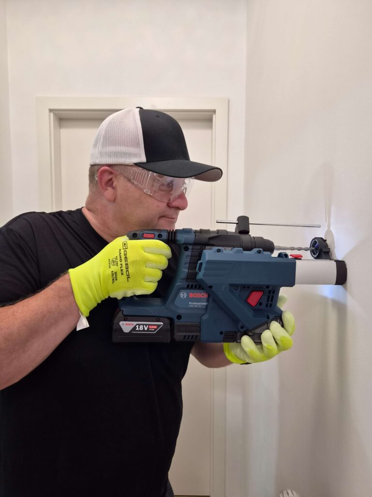 Victor Krauze der Handwerker in Berlin bohrt in die Wand